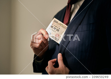 A man who puts a bundle in his pocket 109650249
