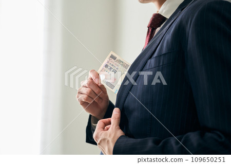 A man who puts a bundle in his pocket A man who puts a bundle in his pocket 109650251