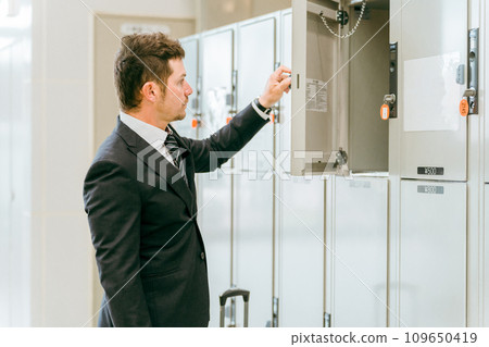 A businessman leaving his luggage in a coin locker at a station or commercial facility (overseas travel, carry-on bag, cabinet) 109650419
