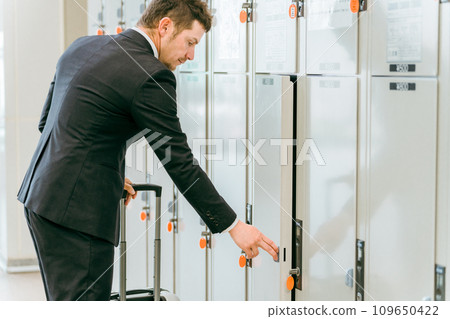 A businessman leaving his luggage in a coin locker at a station or commercial facility (overseas travel, carry-on bag, cabinet) 109650422