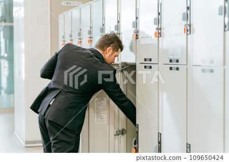 A businessman leaving his luggage in a coin locker at a station or commercial facility (overseas travel, carry-on bag, cabinet) 109650424
