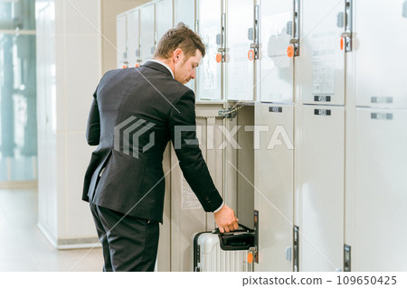 A businessman leaving his luggage in a coin locker at a station or commercial facility (overseas travel, carry-on bag, cabinet) 109650425