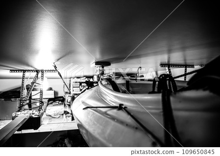 Selective focus on the side of a kayak that has used a Hoist and pulley system to store on the ceiling of a garage. 109650845