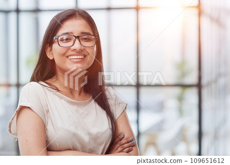 portrait of a smiling business woman with her arms crossed against 109651612