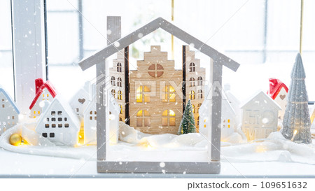 Cozy Christmas decor tiny house of small size on window sill with snow outside the window. Gift for New Year. Insurance, moving to new house, mortgage, rent and purchase real estate 109651632