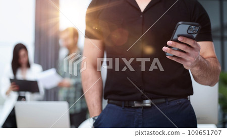 Close-up of a smartphone screen in the hands of a businessman. 109651707