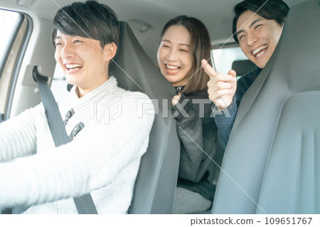 Young men and women enjoy driving around in a shared car 109651767