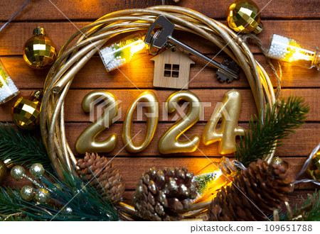 House key with keychain cottage on festive brown wooden background with stars, lights of garlands. New Year 2024 wooden letters, greeting card. Purchase, construction, relocation, mortgage, insurance House key with keychain cottage on festive brown wooden background with stars, lights of garlands. New Year 2024 wooden letters, greeting card. Purchase, construction, relocation, mortgage, insurance 109651788