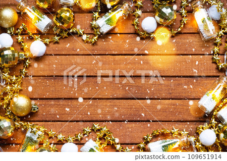 Festive frame with a place for Christmas and New Year's theme text. Sequins, stars, garland on brown wooden background. Copyspace, greeting card Festive frame with a place for Christmas and New Year's theme text. Sequins, stars, garland on brown wooden background. Copyspace, greeting card 109651914
