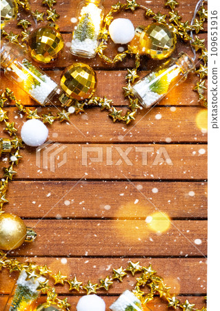 Festive frame with a place for Christmas and New Year's theme text. Sequins, stars, garland on brown wooden background. Copyspace, greeting card Festive frame with a place for Christmas and New Year's theme text. Sequins, stars, garland on brown wooden background. Copyspace, greeting card 109651916