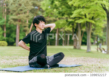 Young Asian man doing yoga, Pilates, meditation, and mindfulness in the forest/park Young Asian man doing yoga, Pilates, meditation, and mindfulness in the forest/park 109652217
