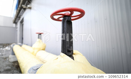 Huge industrial red valve on main heating pipeline 109652314