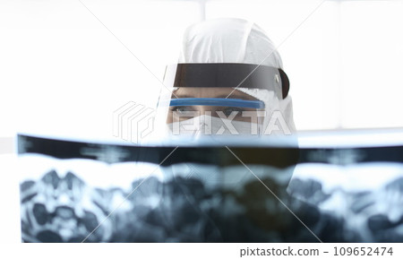 Doctor in protective antiplague suit looking at xray 109652474