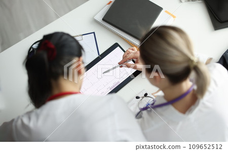 Doctors studying electrocardiogram on digital tablet closeup 109652512