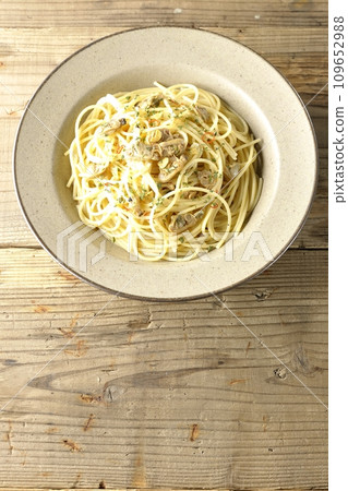 An overhead shot of Vongole Bianco with lots of clams, red chili peppers, Italian parsley, and garlic chips 109652988
