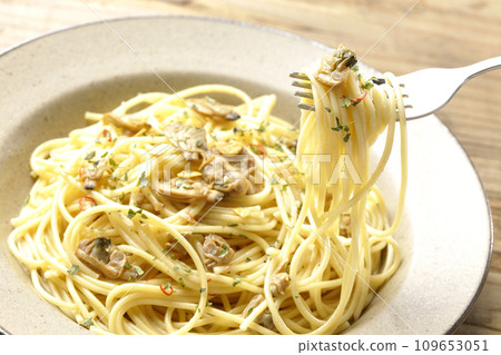 Eat Vongole Bianco with lots of clams, red chili peppers, Italian parsley, and garlic chips. Eat Vongole Bianco with lots of clams, red chili peppers, Italian parsley, and garlic chips. 109653051