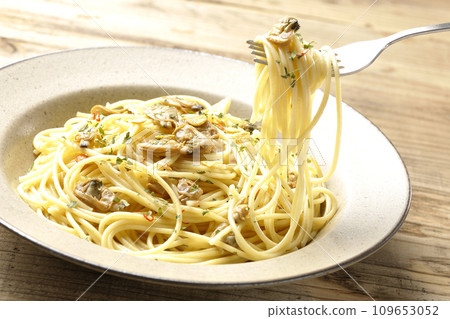 Eat Vongole Bianco with lots of clams, red chili peppers, Italian parsley, and garlic chips. 109653052