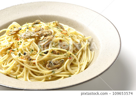 Vongole Bianco with lots of clams, red chili peppers, Italian parsley, and garlic chips photographed against a white background 109653574