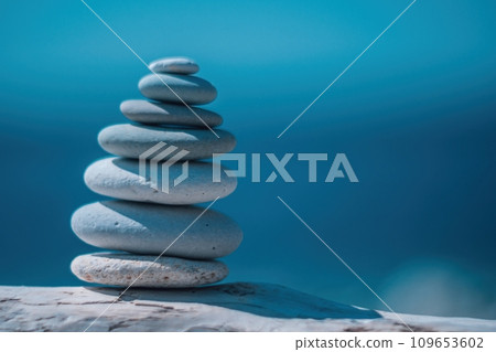 Balanced pebble pyramid on the beach on a sunny day. Abstract Sea bokeh on the background. Selective focus. Zen stones on the sea beach, meditation, spa, harmony, calmness, balance concept Balanced pebble pyramid on the beach on a sunny day. Abstract Sea bokeh on the background. Selective focus. Zen stones on the sea beach, meditation, spa, harmony, calmness, balance concept 109653602