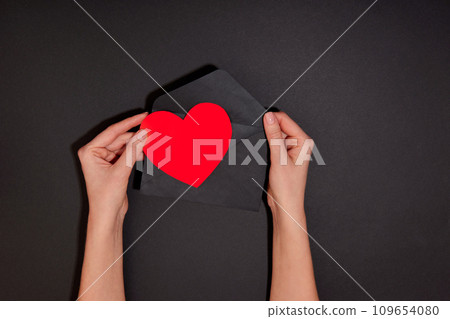 Hand puts heart envelope or takes heart out of envelope Send heart mail envelope 109654080