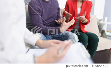 Young couple communicating with psychologist in office closeup Young couple communicating with psychologist in office closeup 109654422