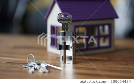 Keyhole and keys lying on background of toy wooden house Keyhole and keys lying on background of toy wooden house 109654424