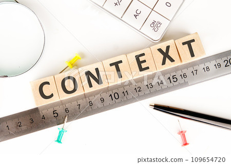 CONTEXT text of non-wooden cubes next to a calculator, pen, measuring ruler, magnifying glass on a white background 109654720