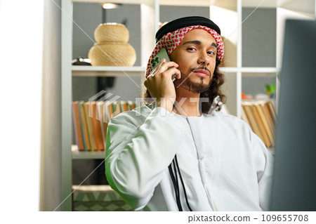 Young Arab businessman talking on the phone in the office 109655708
