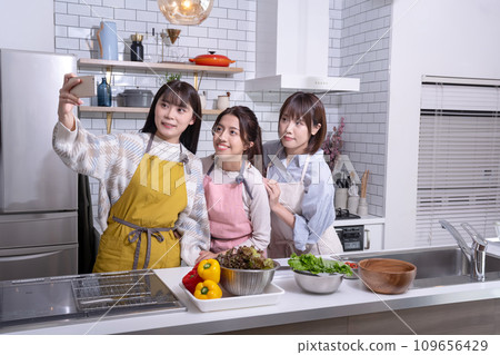 Three good friends taking a photo in the kitchen Three good friends taking a photo in the kitchen 109656429