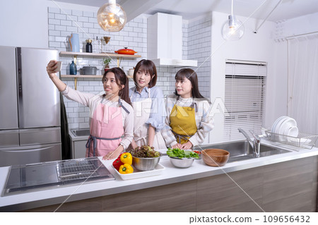 Three good friends taking a photo in the kitchen 109656432