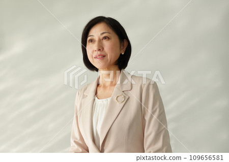 Smiling middle-aged woman wearing a pearl brooch 109656581