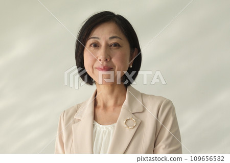 Smiling middle-aged woman wearing a pearl brooch 109656582
