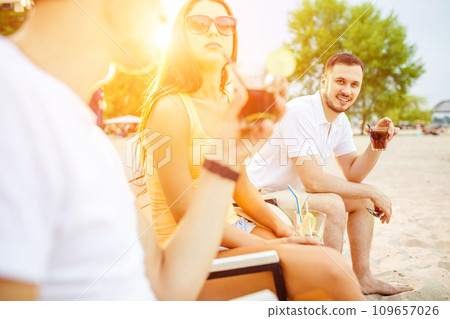 Young people enjoying summer vacation sunbathing drinking at beach bar Young people enjoying summer vacation sunbathing drinking at beach bar 109657026
