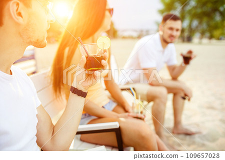 Young people enjoying summer vacation sunbathing drinking at beach bar 109657028