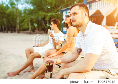 Young people enjoying summer vacation sunbathing drinking at beach bar 109657048