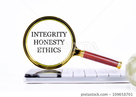 lINTEGRITY HONESTY ETHICS ettering through a magnifying glass on a calculator and part of a magic ball in the foreground without focus lINTEGRITY HONESTY ETHICS ettering through a magnifying glass on a calculator and part of a magic ball in the foreground without focus 109658701