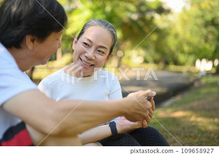 Happy active middle aged couple having fun talking and relaxing in the park. Retirement lifestyle concept Happy active middle aged couple having fun talking and relaxing in the park. Retirement lifestyle concept 109658927