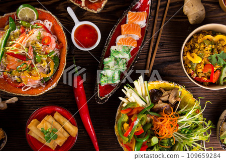 Assorted Asian food set. Chinese noodles, fried rice, dumplings, peking duck, dim sum, spring rolls. Famous Chinese cuisine dishes on table. Top view Assorted Asian food set. Chinese noodles, fried rice, dumplings, peking duck, dim sum, spring rolls. Famous Chinese cuisine dishes on table. Top view 109659284