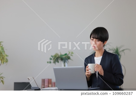 女商人1雙手拿著咖啡杯檢查文件 女商人1雙手拿著咖啡杯檢查文件 109660287