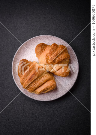 Delicious crispy baked sweet croissants with filling on a ceramic plate Delicious crispy baked sweet croissants with filling on a ceramic plate 109660873