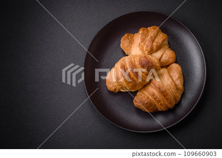 Delicious crispy baked sweet croissants with filling on a ceramic plate 109660903