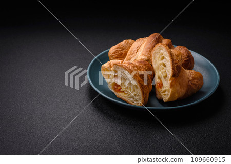 Delicious crispy baked sweet croissants with filling on a ceramic plate Delicious crispy baked sweet croissants with filling on a ceramic plate 109660915