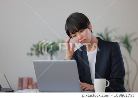 Business woman who is not feeling well and grimacing 1 109661785