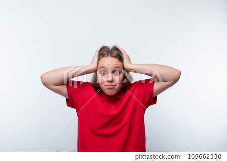 Funny girl with brown hair laughs loudly and holds her head 109662330
