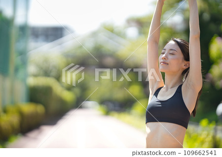 Rear view of a young woman in sportswear running in the greenery Rear view of a young woman in sportswear running in the greenery 109662541