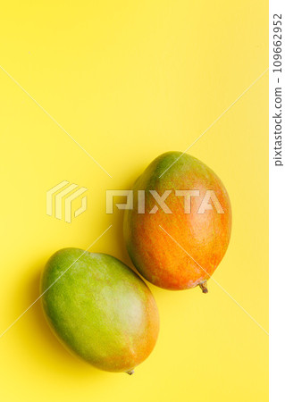 Ripe mango fruit on yellow background. Top view. Ripe mango fruit on yellow background. Top view. 109662952