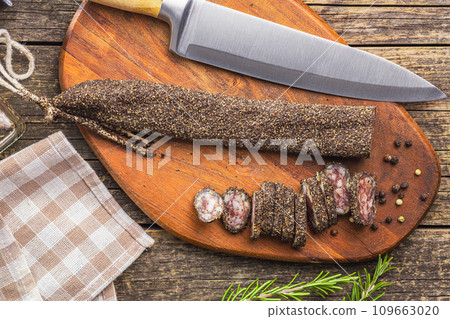 Smoked dried sausage. Sliced sausage on cutting board. Top view. 109663020