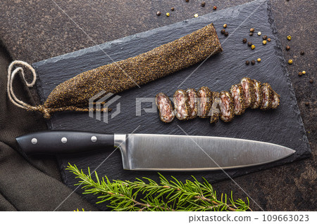 Smoked dried sausage. Sliced sausage on cutting board. Top view. Smoked dried sausage. Sliced sausage on cutting board. Top view. 109663023