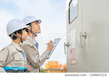 Engineer inspecting substation equipment 109663519