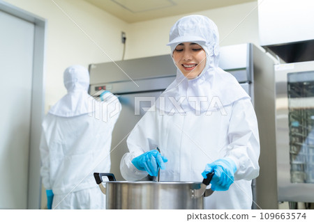 一個穿著白大褂的女人在廚房做飯 109663574